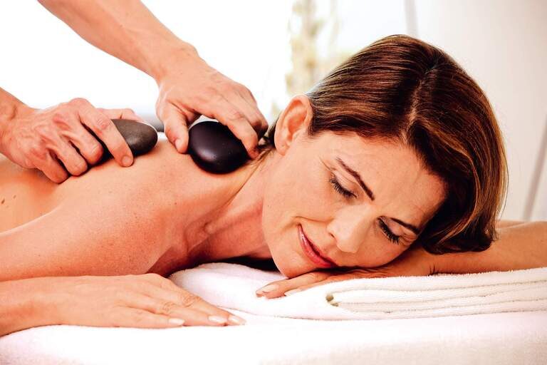 Eine Frau genießt eine Massage im Spa der Johannesbad Therme Bad Füssing.